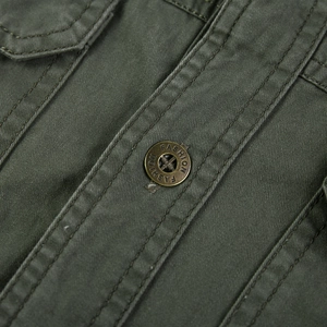 Gros plan détaillé de la veste en coton vert armée avec coutures doubles et bouton en métal