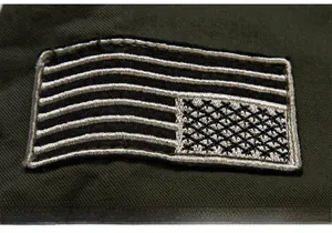 Close-up of military green twill cotton jacket featuring a detailed flag embroidery patch