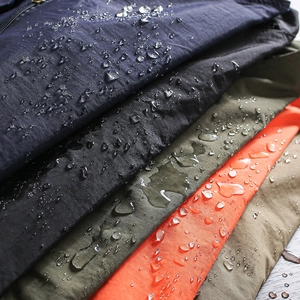 Waterproof multi-pocket cargo vest fabric detail with water droplets on mesh material