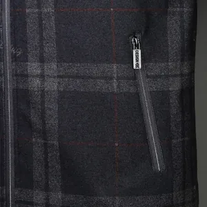 Close-up of slim fit plaid jacket fabric with a metal zipper and red accents