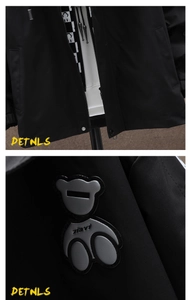 Detail view of black casual jacket with white hoodie lining and bear patch ornament