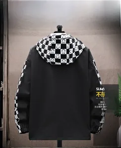 Detail of men's black hooded jacket featuring checkered sleeves with smiley patterns