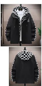 Detail of black hooded jacket featuring checkered lining and a small bear pendant decoration