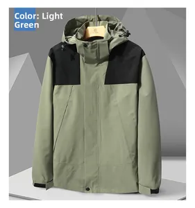 Détail d'une veste outdoor vert clair avec empiècements noirs et capuche coupe-vent