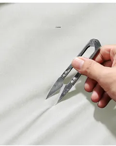 Détail macro de ciseaux en métal testant le tissu résistant aux rayures de la veste outdoor