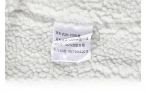 Detail of product wash care label on white fleece lining showing 100% cotton material