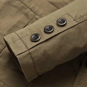 Detailed macro view of khaki cotton blazer cuff with three classic brown buttons
