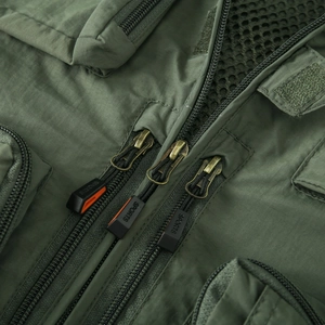 Détail de gilet de pêche vert armée montrant la fermeture éclair et la doublure filet
