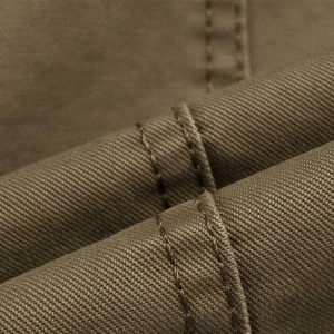Macro view of khaki twill fabric highlighting high-quality double stitching detail