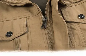 Detail of khaki cotton work jacket featuring a durable metal zipper and flap chest pocket