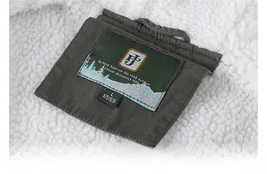 Detail of soft white fleece lining and green brand label on the outdoor jacket interior