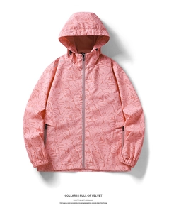 Detail of pink windbreaker jacket with tropical monstera leaf print and drawstring hood