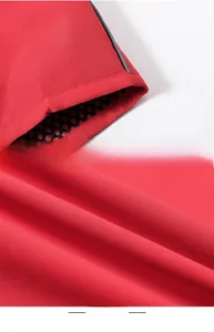 Detail view of red fishing vest showing reflective stripe and black mesh lining