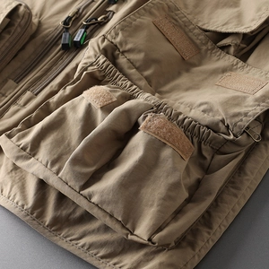 Close-up of khaki tactical vest featuring multi-pockets and durable zipper details
