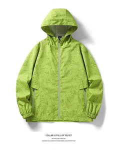 Detail of green windbreaker with tropical monstera leaf print and elastic cuffs
