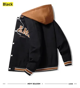 Detail of black hooded baseball jacket featuring AM embroidery and snap button closure