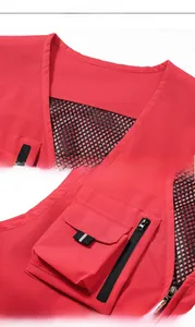 Detail of red multi-pocket vest showing V-neck design, mesh lining, and secure zipper pockets