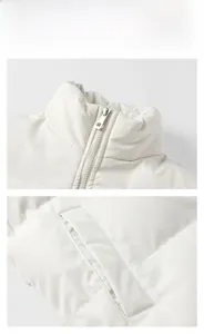 Detail view of the stand-up collar, silver metal zipper, and side pockets of white padded jacket