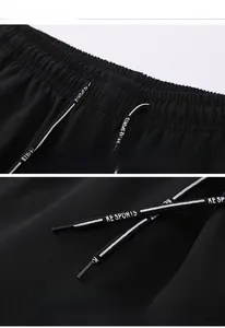 Detail view of elastic waist on black sports trousers with KE SPORTS woven drawstring