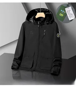 Detail of black outdoor hooded jacket featuring brand logo and chest zipper pocket