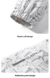 Detail of elastic cuffs and reflective logo print on tropical leaf sports jacket