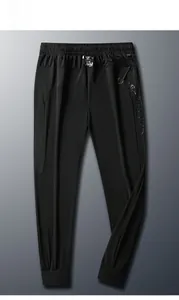 Detail of men's quick-dry black pants showing mesh panels and elastic waistband