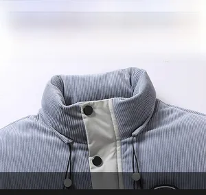 Macro detail of light blue corduroy puffer vest featuring stand collar and black snap buttons