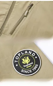 Detailed macro view of khaki utility jacket zipper pocket and round Topland eagle patch