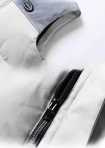 Detailed close-up of blue corduroy shoulder patch and durable black resin zipper on gray vest