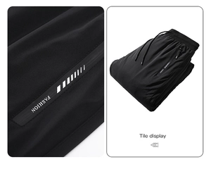 Detail view of black down pants with white Fashion text and zip pocket features