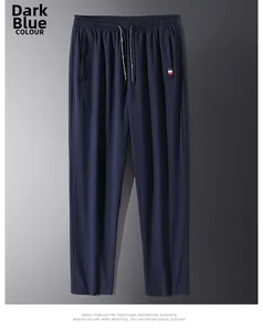Close-up of men's dark blue joggers featuring elastic drawstring waist and side pockets