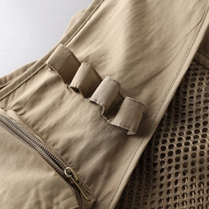 Close-up of tactical vest featuring metal zipper, utility webbing, and mesh lining detail
