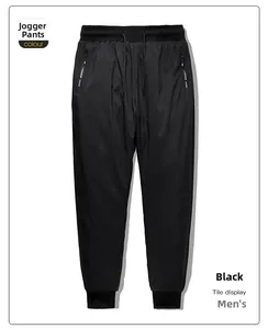 Detail of black cuffed down trousers with elastic drawstring waist and side zipper pocket