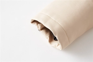 Macro shot of faux leather texture and precise stitching on beige biker jacket cuff