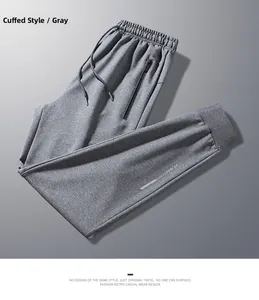 Detail of grey knitted joggers featuring drawstring waist and decorative zipper pockets