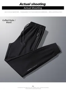 Detail of black jogger pants with ATHL reflective logo and hidden zipper pocket
