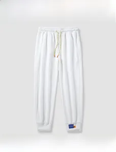 Detail view of white drawstring jogger pants with elastic waist and woven cords