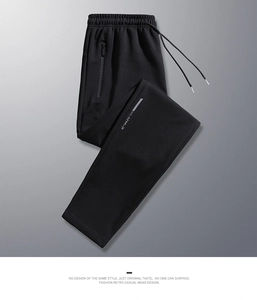 Detail of black sports trousers with zipper pocket and reflective ATHL-D lettering
