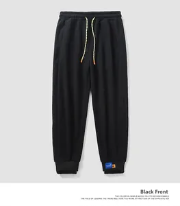 Detail of black jogger pants featuring drawstring waist and elastic cuffs for a casual look