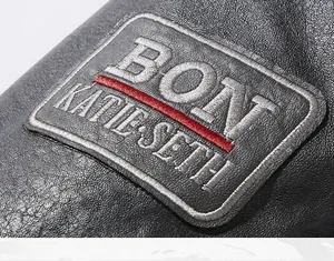 Detailansicht der schwarzen Lederjacke mit gesticktem Patch und feiner Ledermaserung