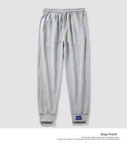 Detail of grey sweatpants showing elastic drawstring waist and ribbed ankle cuffs