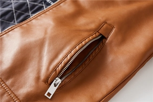 Detail of brown faux leather jacket with metal zipper and blue diamond quilted lining