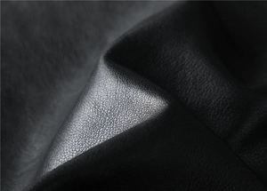 Macro shot showing high-quality black faux leather texture with fine lychee grain detail