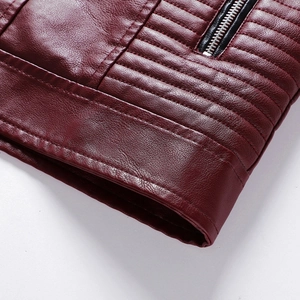 Dettaglio macro della giacca in pelle PU bordeaux con cuciture a coste e zip metallica