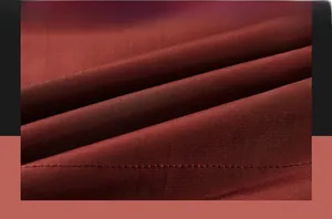 Detailed macro view of soft burgundy fabric with clean stitching and refined texture
