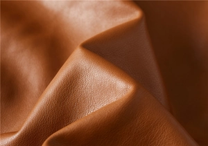 Macro view of brown faux leather texture with litchi grain and soft matte finish