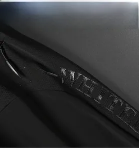 Close-up of black ice silk fabric with mesh stitching and polished printed lettering