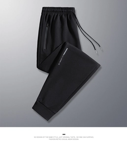 Detail of men's black joggers showing elastic drawstring waist and textured zipper pocket