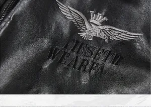 Detail einer schwarzen Lederjacke mit Adler- und Kronenstickerei auf der Brust