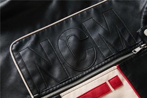 Detail of NCM patchwork letter embroidery on black and beige faux leather jacket